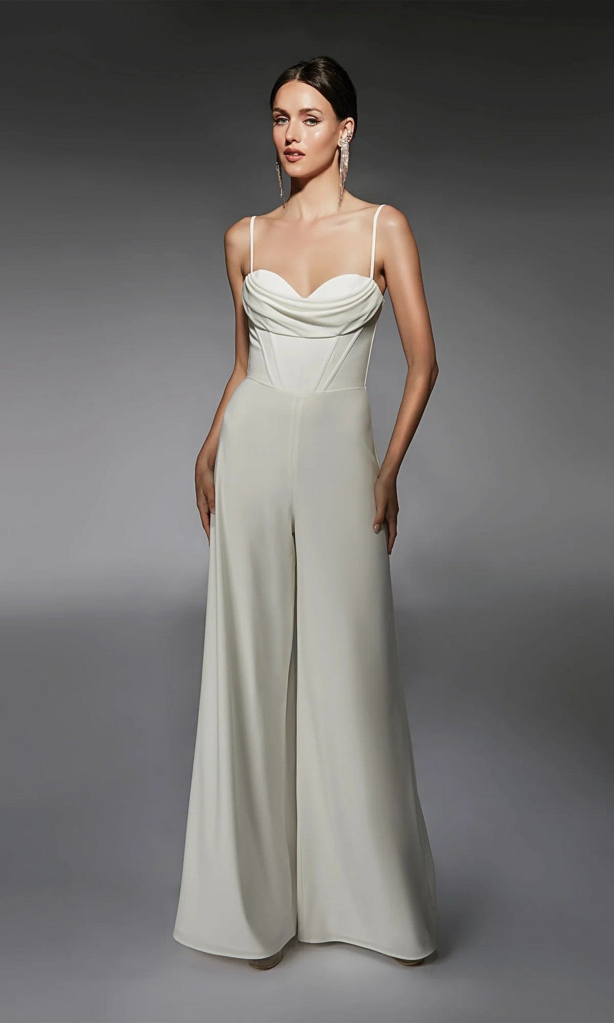 A woman poses against a plain, dark background in the Alyce 70075 Long Formal Jumpsuit, featuring thin straps, a draped corset-boned bodice, and a wide-leg silhouette.